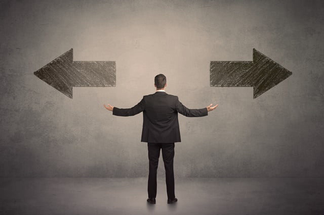 Business man taking a decision while standing in front of two gr