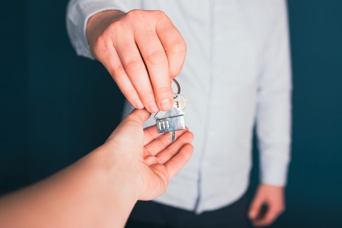 Female hand taking key from realtor buying renting new house, ge