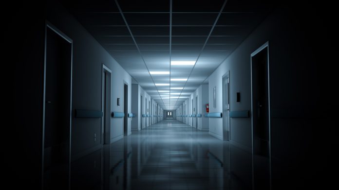 Hospital emergency room corridor with few lights on.