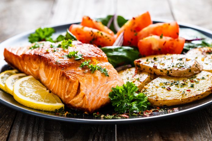 Fried,Salmon,Steak,With,Potatoes,And,Vegetables,On,Wooden,Table